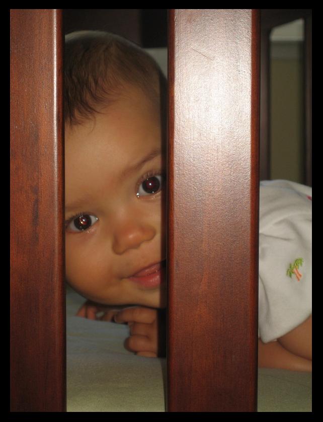 Ari peeking between crib slats